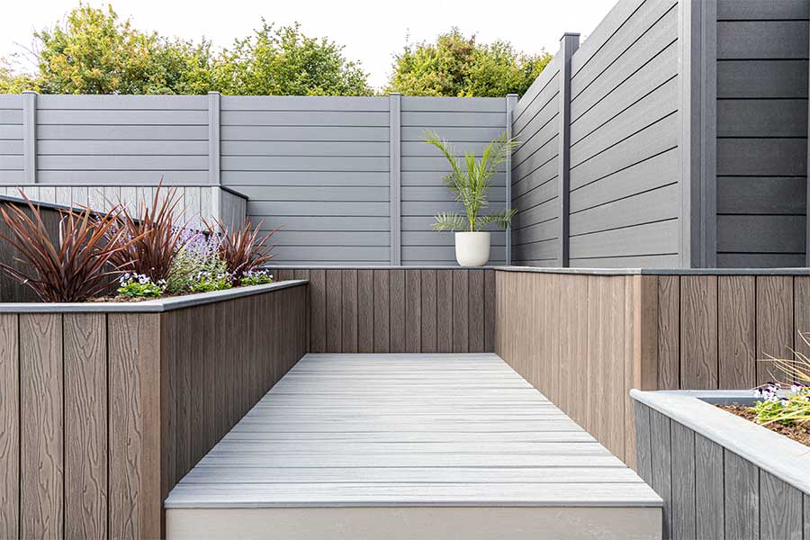 Large concrete block retaining walls clad with composite timber for a decking display area at the Oxford branch of AWBS